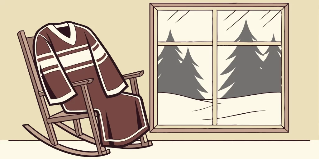 Canadian hockey sweater draped over a rocking chair by snowy window.