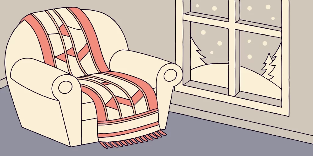 Cozy sweater jersey draped over armchair by window.