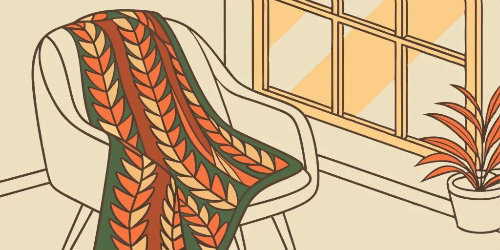 Custom logo sweater on a cozy chair.